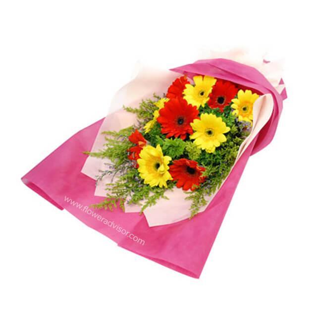 Bouquet of 10 mixed gerbera daisies in red and yellow with greenery, wrapped in pink paper.