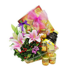 Gift basket with bird's nest juice, lilies, small jars, and decorative pink ribbon