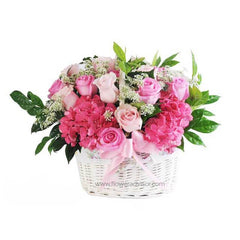 Basket of assorted pink roses and hydrangeas with greenery and baby's breath