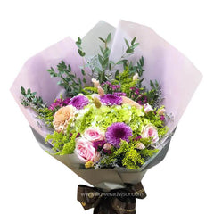 Bouquet with peach hydrangeas, purple flowers, pink roses, and lush green foliage