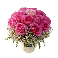 Bouquet of 12 fresh pink roses in a vase with white baby’s breath flowers