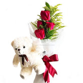 Four red rose hand bouquet with green fillers and teddy bear