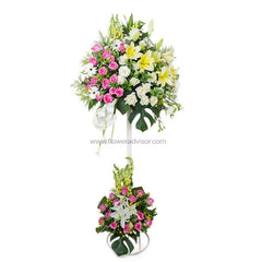 Elegant two-tier floral arrangement with pink roses, white lilies, and yellow lilies, ideal for flower delivery