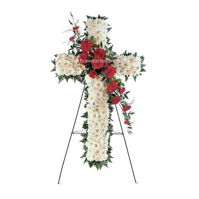 Floral cross arrangement with white chrysanthemums and red carnations on a black stand
