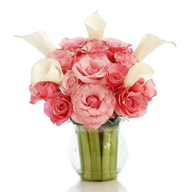 Elegant bouquet of pink roses and white calla lilies in a clear glass vase, fresh floral arrangement