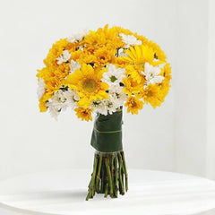 Bouquet of yellow gerbera daisies and white chrysanthemums on a white table