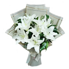 Elegant bouquet of fresh white lilies wrapped in beige paper with green foliage, ideal for flower delivery
