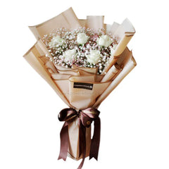 Elegant bouquet with white roses, pink and white baby's breath, wrapped in beige paper with brown ribbon