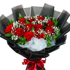 Bouquet of fresh red roses and white baby's breath flowers wrapped in black paper with a red ribbon, fresh flower delivery