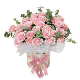 Elegant bouquet of fresh pink roses with eucalyptus leaves in a cream hatbox tied with a pink ribbon