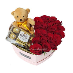 Heart-shaped gift box with red roses, Ferrero Rocher chocolates, and a teddy bear with yellow bow