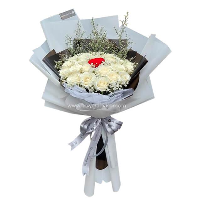 Elegant bouquet of white roses with a single red rose center, accented with greenery and white wrapping