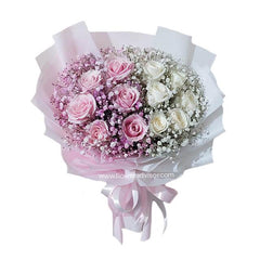 Elegant bouquet of pink and white roses with baby's breath, wrapped in white and pink paper with ribbon