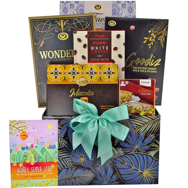 Gift hamper with assorted chocolates, coffee, cookies, and classic fruit cake in decorative box with teal ribbon