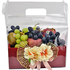 Fruit gift box with grapes, kiwi, dragon fruit, and decorative flowers in red packaging