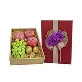 Fruit gift box with red apples, green grapes, and kiwis beside a red decorative box with purple flowers