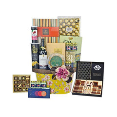 Luxury gift hamper with wine, chocolates, nuts, gourmet snacks, and a floral decorated box