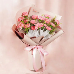 Bouquet of fresh pink carnations wrapped in beige and white paper with pink ribbon, fresh flower delivery Malaysia