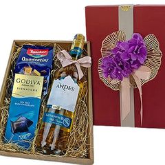 Elegant gift box with Andes Sauvignon Blanc wine, Godiva sea salt dark chocolate, Loacker Quadratini wafers, decorated with purple flowers