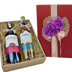 Gift box with two wine bottles, Premio red and Andes white, decorated with purple flowers and beige ribbons
