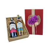 Elegant gift box with two wine bottles and red box decorated with purple flowers and ribbon