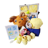 Baby gift hamper with yellow clothes, stuffed ram toy, Minnie Mouse teether, baby bottle, and accessories