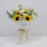 Sunflower and white rose bouquet wrapped in white paper with decorative ribbons, fresh flower delivery