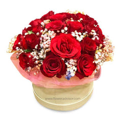 Elegant round bouquet of vibrant red roses and white baby's breath in a beige box, fresh flower delivery