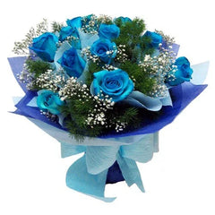 bouquet of vibrant blue roses with baby's breath and greenery wrapped in blue and purple paper