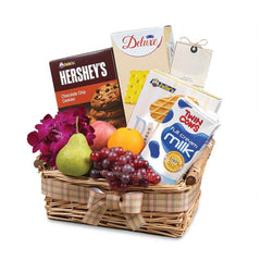 Gift basket with Hershey's cookies, Twin Cows milk, Deluxe crackers, fruit, and purple orchids wrapped with plaid ribbon