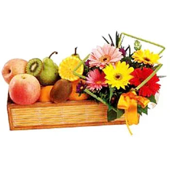 Fruit basket with fresh apples, pears, oranges, and colorful gerbera daisy flowers