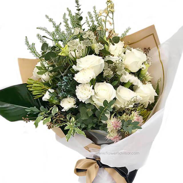 Mixed bouquet with 10 white roses, assorted white flowers, and green foliage in wrapping