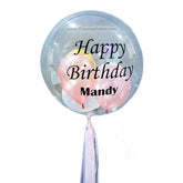 Transparent bubble balloon with pastel balloons inside, 'Happy Birthday Mandy' text, and a ribbon.