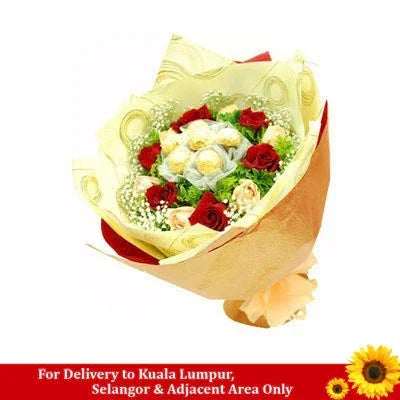 Bouquet with Ferrero Rocher chocolates, red roses, white flowers, and gold wrapping.