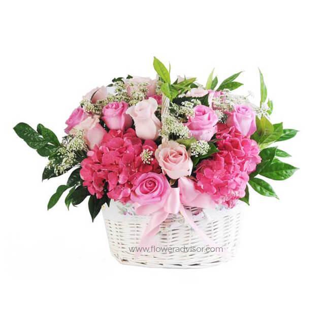 Basket of assorted pink roses and hydrangeas with greenery and baby's breath