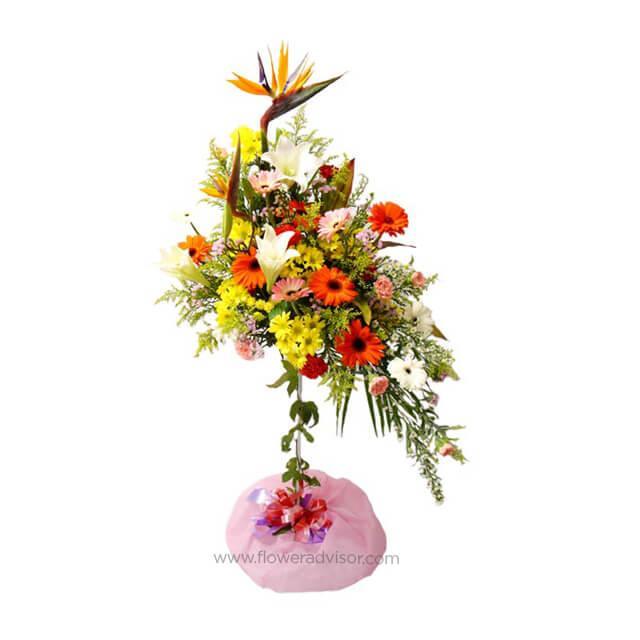 Colorful standing flower arrangement with lilies, Bird of Paradise, carnations, and daisies