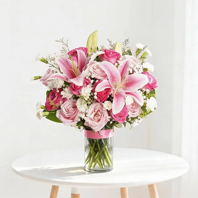Pink rose, lily and white carnation arrangement in a clear glass vase