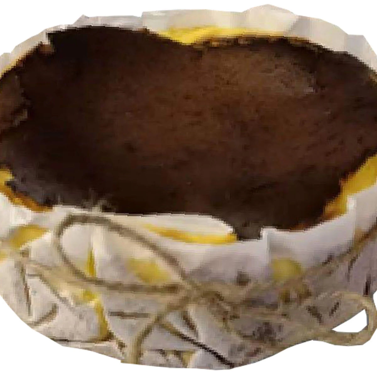Basque burnt cheesecake wrapped in parchment paper with twine, close-up view