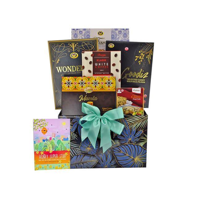 Gift hamper with assorted snacks, cookies, sweets and a green ribbon, perfect for gifting.