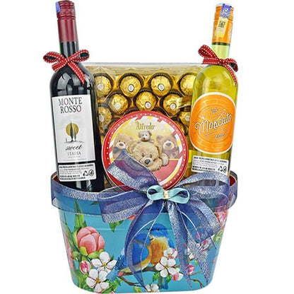 Gift basket with Monte Rosso red wine, Jo Moscato white wine, Ferrero Rocher chocolates, and teddy bear tin, decorated with blue floral basket and bows