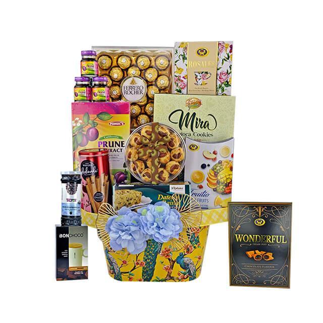 Premium gift basket with assorted chocolates, cookies, prune extract, and decorative blue flowers