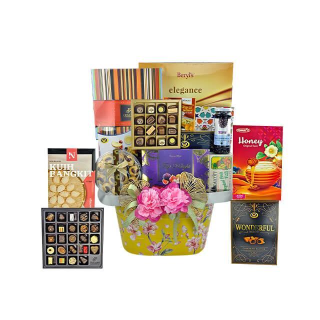 Luxury gift basket with assorted chocolates, honey, cookies, and gourmet treats decorated with pink flowers
