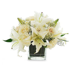 Elegant white lily and rose flower arrangement in a clear glass vase