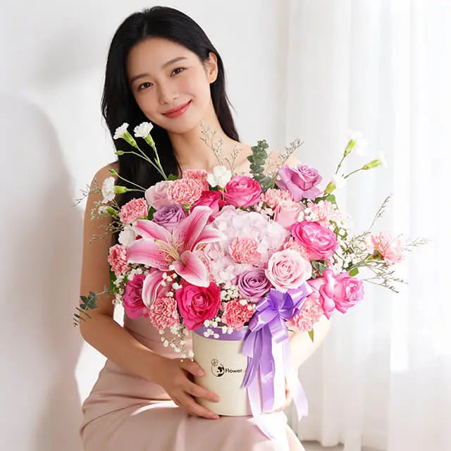 Pink and purple rose, lily and carnation arrangement in a bloom box