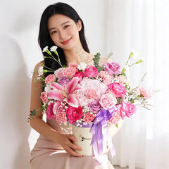 Pink and purple rose, lily and carnation arrangement in a bloom box