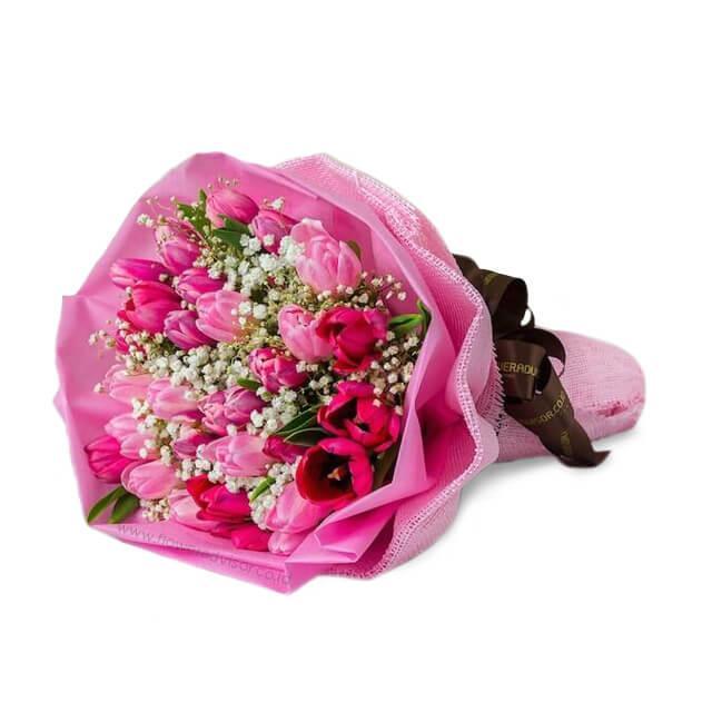 Pink tulip bouquet wrapped in pink paper with baby's breath, romantic flower arrangement