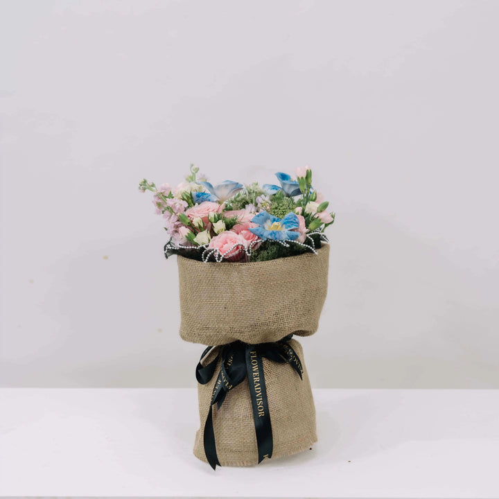 Delancy Harmony - pink roses and blue tulips in a burlap pot